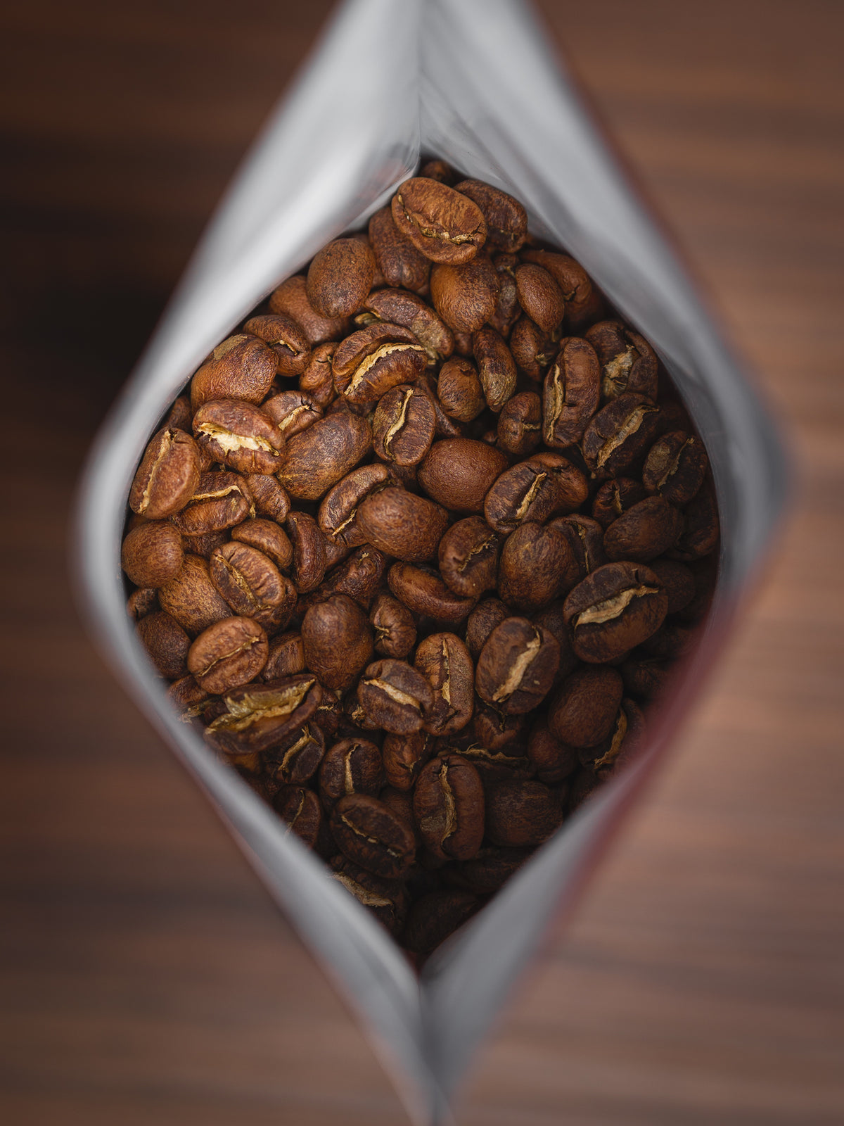 Des grains de café de spécialité vus de dessus, dans un sachet ouvert