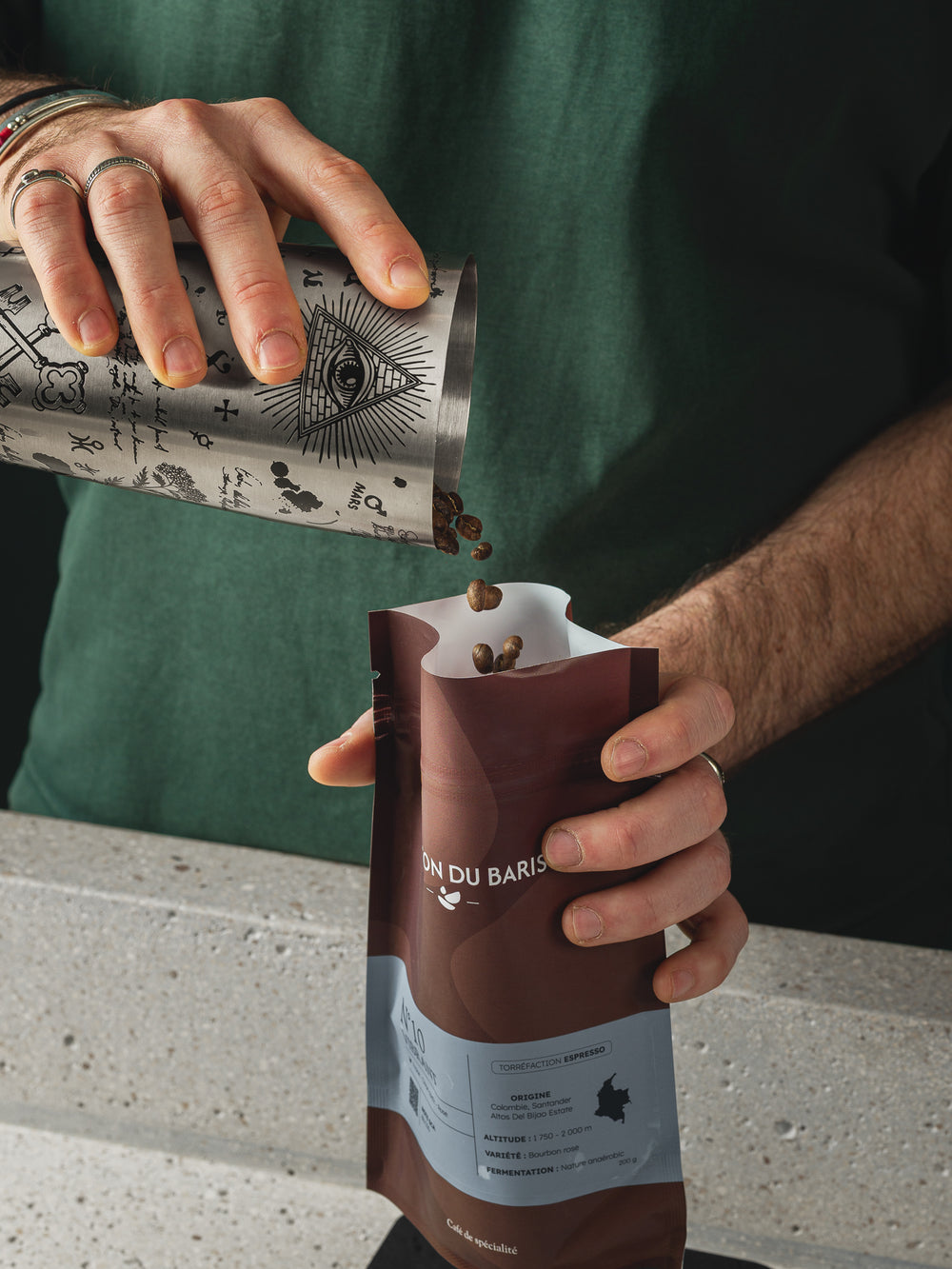 Des grains de café versés dans un sachet de La Maison du Barista