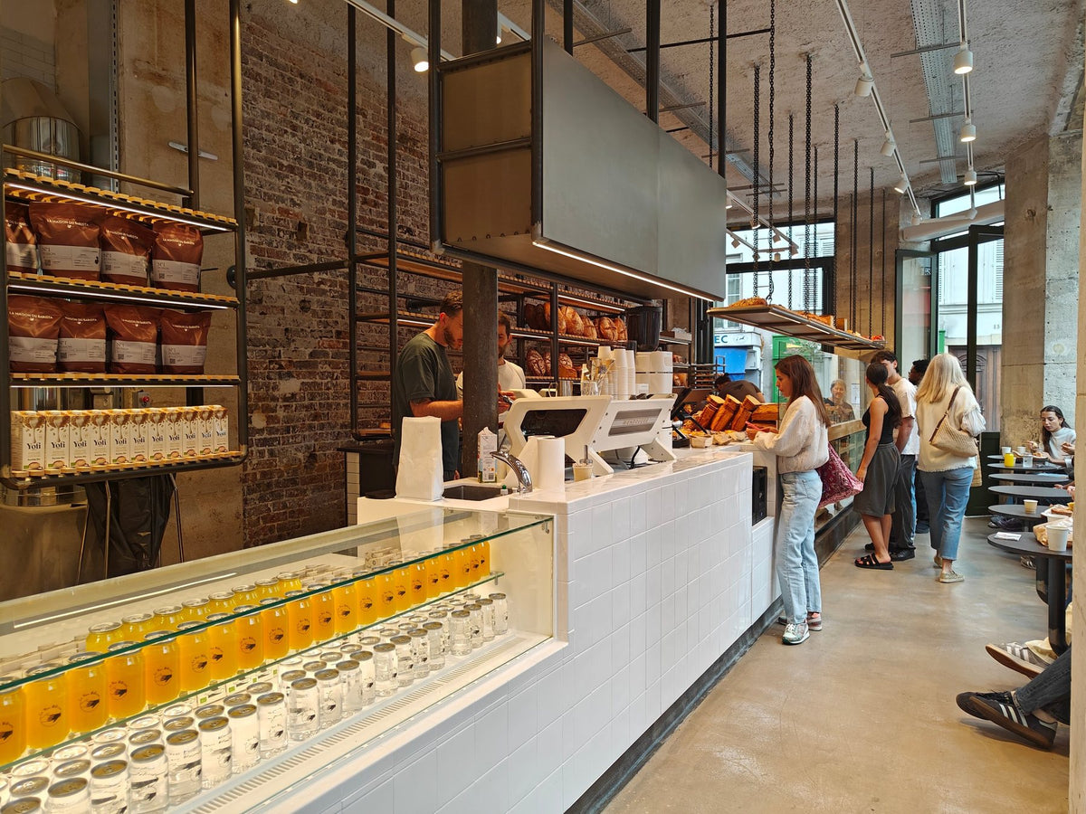Large comptoir de café avec vitrine, machines et étagères de cafés