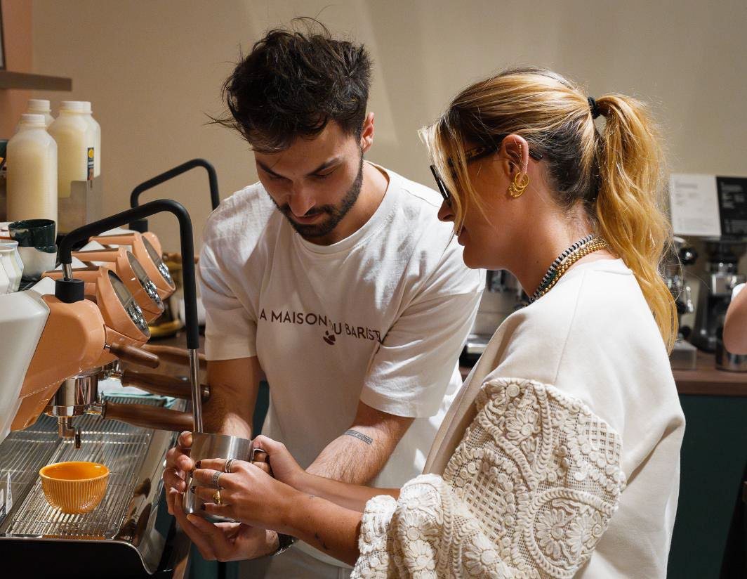 Deux collègues apprennent le latte art avec un barista
